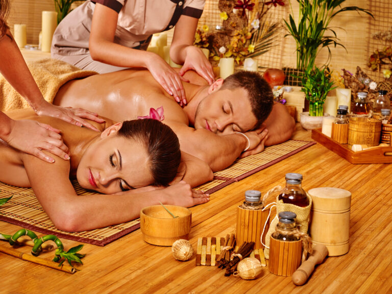 Man and woman relaxing in bamboo spa getting massage.